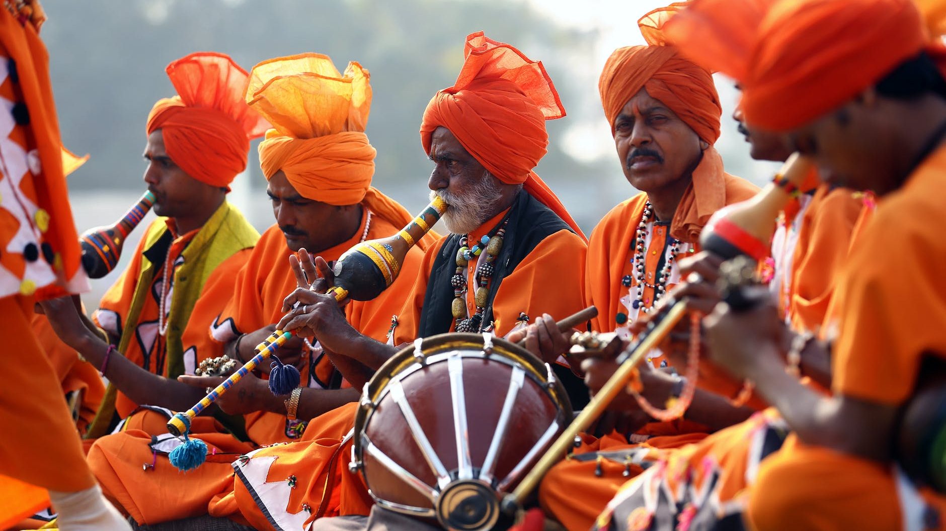 men in orange costumes playing instruments