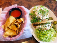 Salsa and chips and a plate of tacos